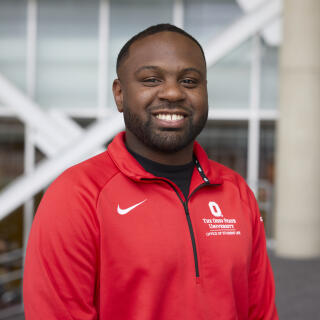 Black male in a red jacket