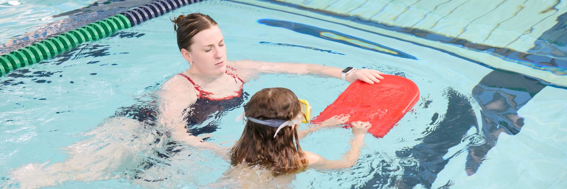 Child and instructor in pool for swim lesson