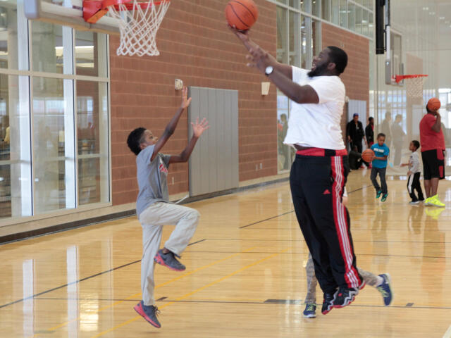 Adult and child playing basketball at RPAC