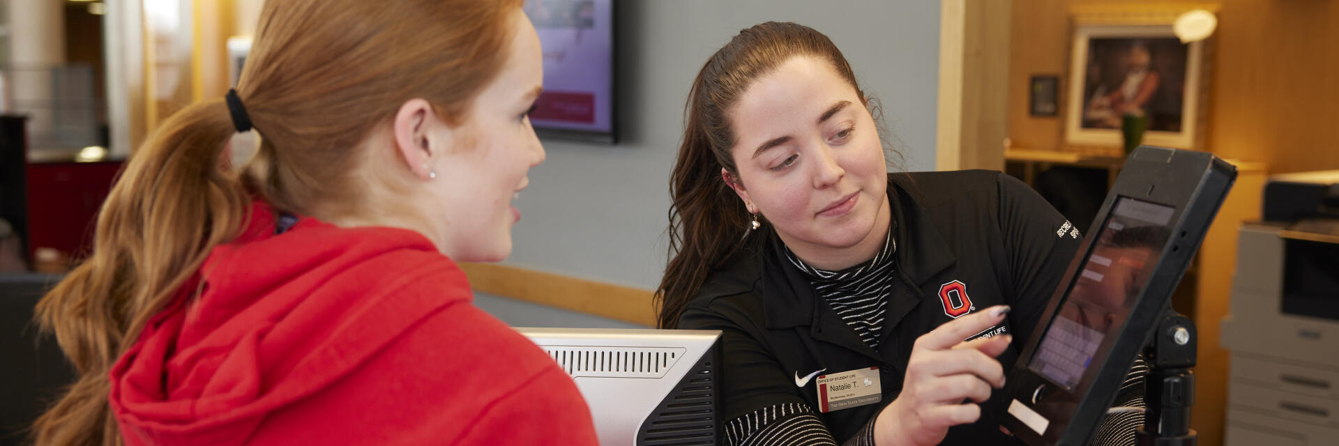 Individual being assisted by front desk staff