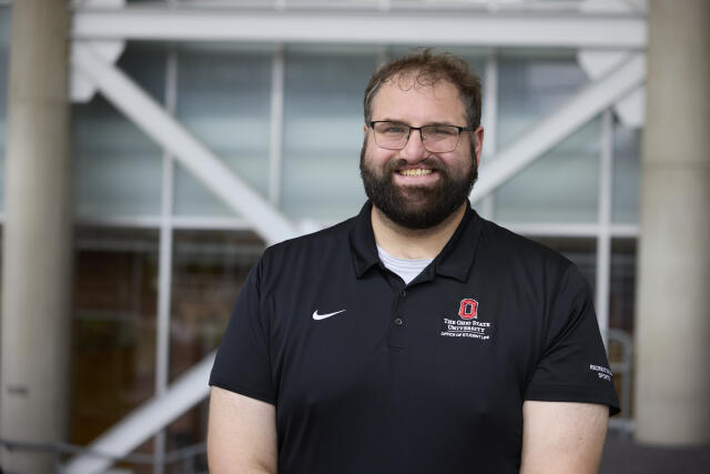 male, black polo, glasses