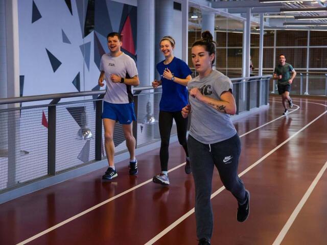 Four participants run together on the indoor track at the RPAC.